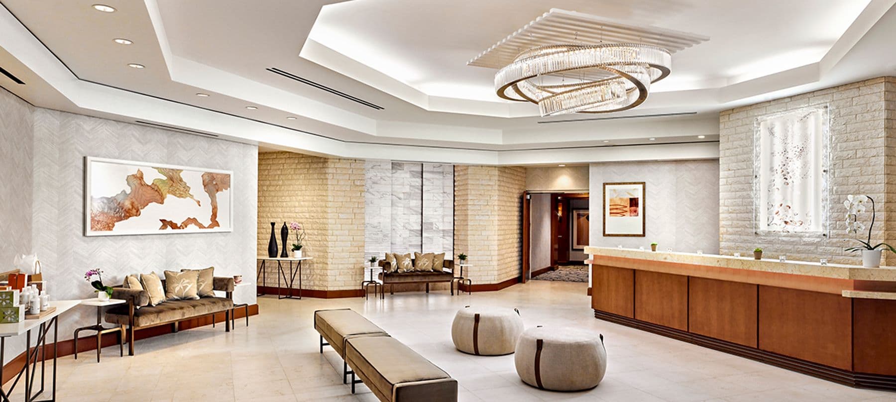 Modern spa lobby with reception desk, seating areas, and contemporary lighting fixture