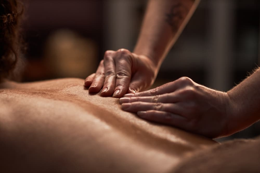 Therapist performing massage on client's back with skilled hand placement