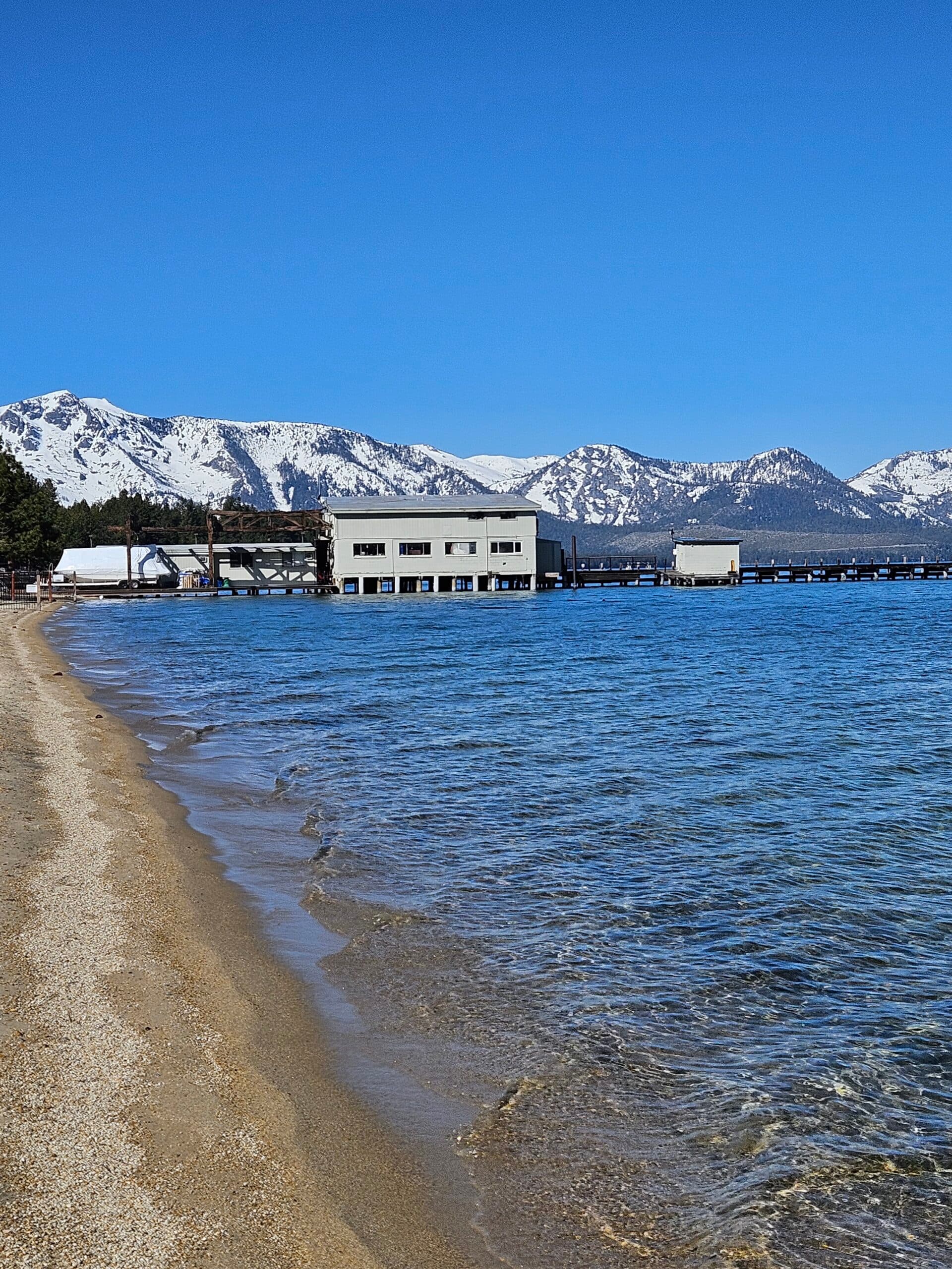 Waterfront facility with snow-capped mountains and sandy beach
