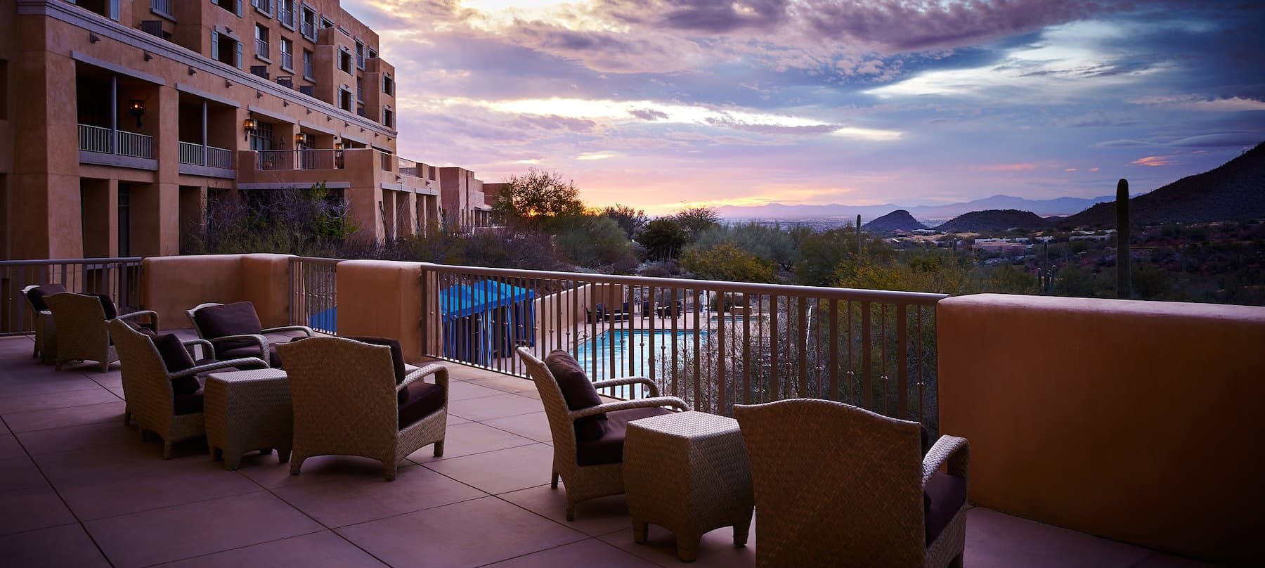 Terrace seating with mountain and desert sunset views overlooking a pool